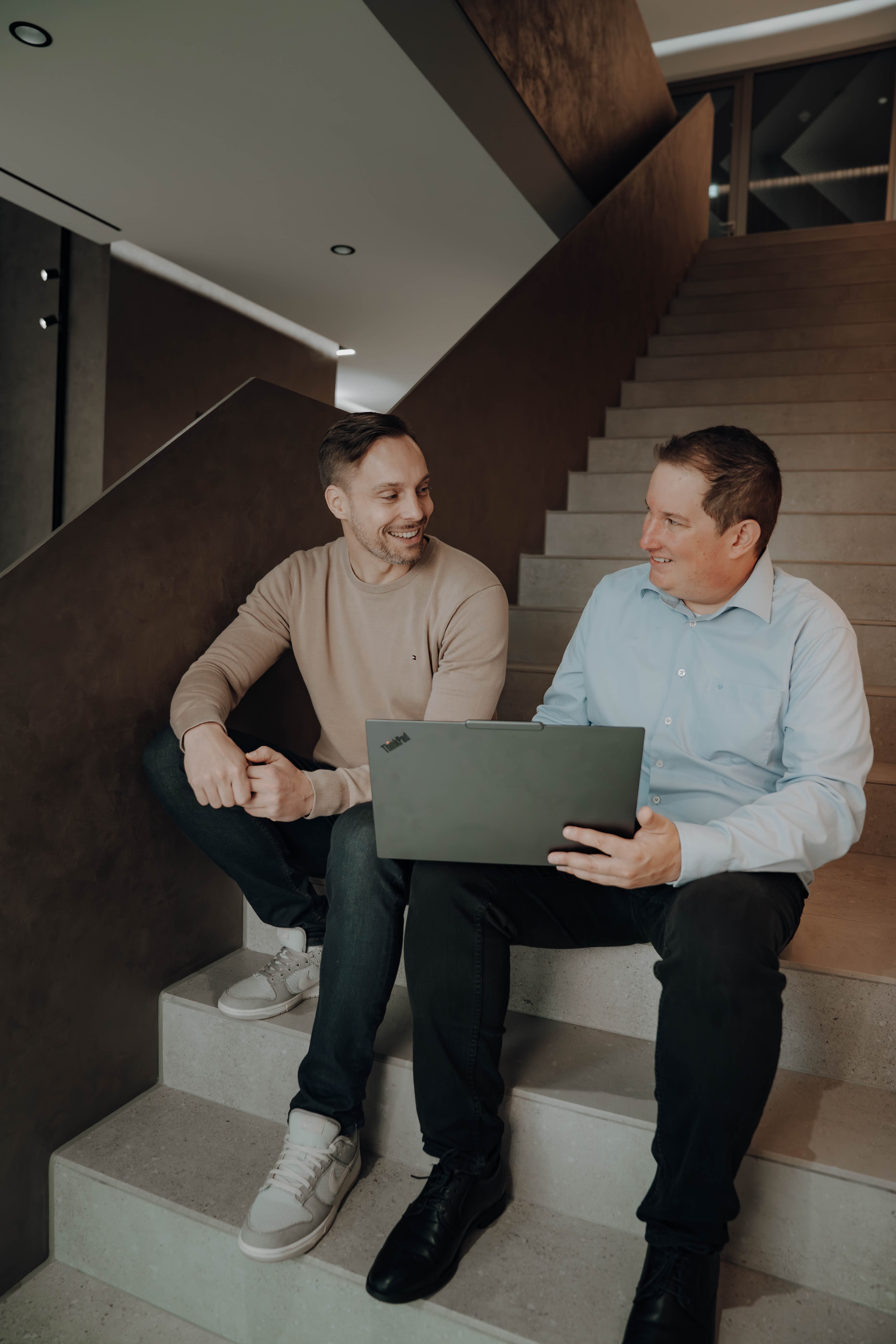 Senior Consultants Michael Möller und Steve im Treppenhaus des experics-Büros.